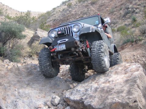 1996 Ford Bronco - A Jeep CJ-7 navigates a rocky trail, demonstrating its off-road capabilities.