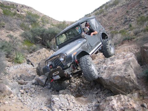 1996 Ford Bronco - A black Jeep Wrangler TJ is shown navigating a challenging rocky terrain, demonstrating its off-road capabilities.
