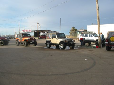 1996 Ford Bronco - A line of off-road vehicles, including Jeeps and a Ford Bronco, are being washed at an outdoor facility.