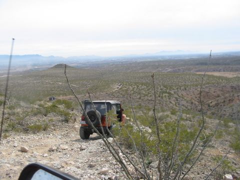 1996 Ford Bronco - A group of off-road vehicles navigate a desert landscape under a hazy sky.