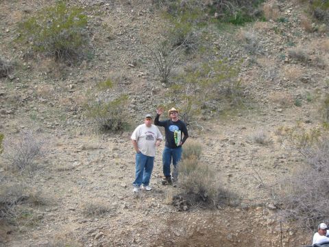 1996 Ford Bronco - Two men are standing on a rocky hillside in a desert environment.