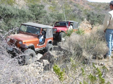 1996 Ford Bronco - Two Jeep Wranglers navigate a challenging rocky trail during an off-road excursion.