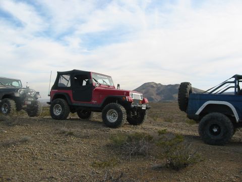 1996 Ford Bronco - Off-road vehicles parked on a desert hillside.