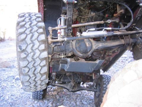 1987 Suzuki Samurai - Close-up of the undercarriage and suspension system of a modified off-road vehicle.