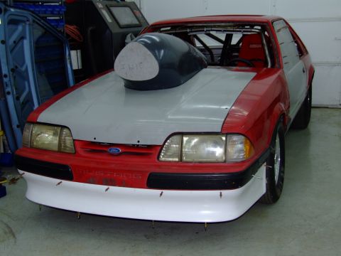 1990 Ford Mustang - This 1990 Ford Mustang features a prominent hood scoop and a roll cage visible through the windows.