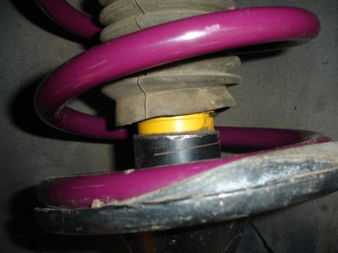1992 Ford Taurus - A close-up view of a vehicle's suspension system, highlighting the coil spring and protective boot.