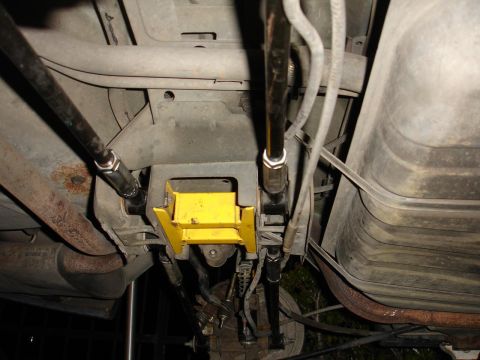 1992 Ford Taurus - Custom rear suspension components, including yellow traction bars and fuel tank, are visible from underneath the vehicle.