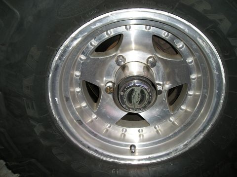 1993 Ford Bronco - A close-up view of a vehicle's wheel, an alloy rim and a WARN locking hub.