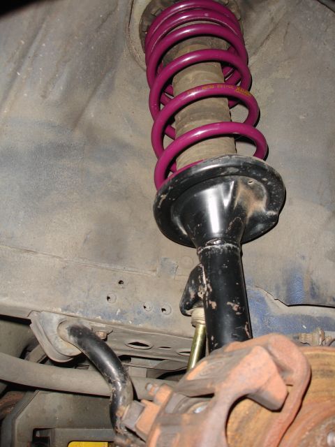 1992 Ford Taurus - This image shows a close-up view of a vehicle's suspension system, focusing on the shock absorber and brake components.