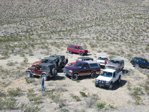 1996 Ford Bronco - A group of SUVs and trucks are gathered in a desert landscape, with one 1996 Ford Bronco visible.