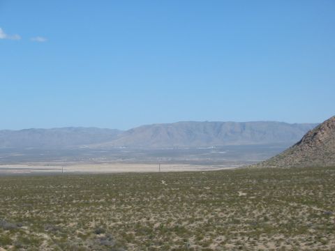 1996 Ford Bronco - A vast desert scene unfolds with mountains on the horizon and sparse vegetation covering the terrain.
