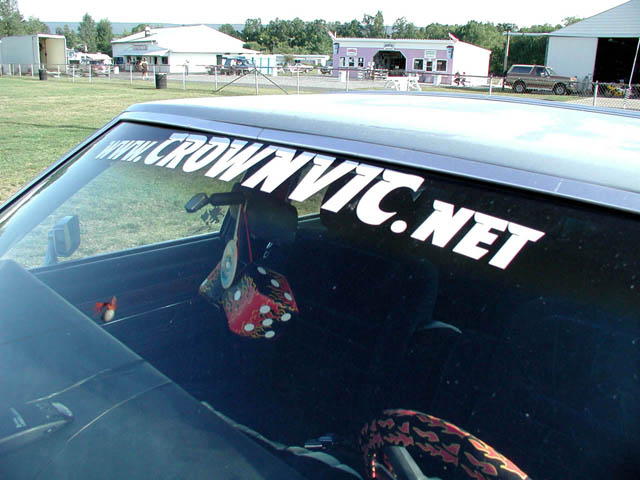 Windshield with WWW.CROWNVIC.NET banner decal, fuzzy flame dice on mirror, flame seat covers inside