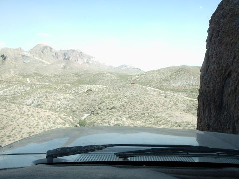 1996 Ford Bronco - Driving through a vast desert landscape with mountains in the distance and a road ahead.
