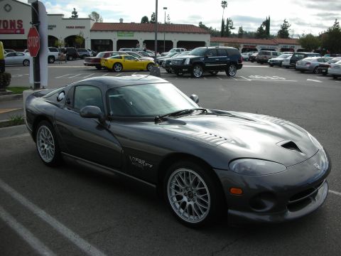 1998 Ford Crown Victoria - dark gray Dodge Viper GTS coupe with mesh wheels parked at a shopping center, a yellow sports car and SUV visible behind.