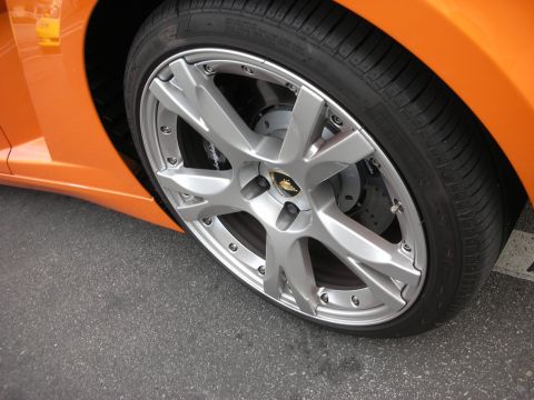 1998 Ford Crown Victoria - Close-up of a silver multi-spoke wheel and low-profile tire on an orange Lamborghini Gallardo, gold crest visible on the center cap.