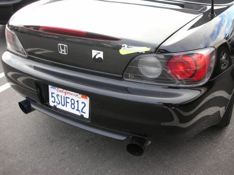 1998 Ford Crown Victoria - Rear close-up of a black Honda S2000 showing carbon-fiber-look trunk trim, dual exhaust tip and a California license plate.