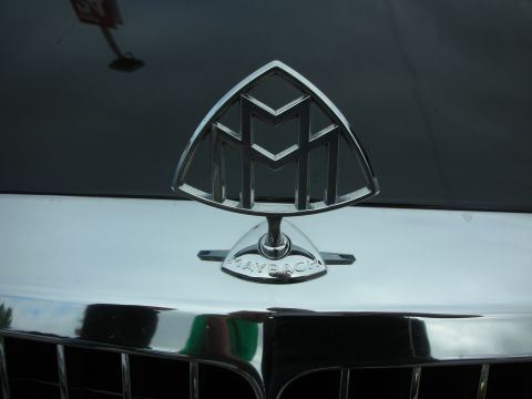 1998 Ford Crown Victoria - close-up of the chrome Maybach double-M hood ornament and badge mounted on a dark car.