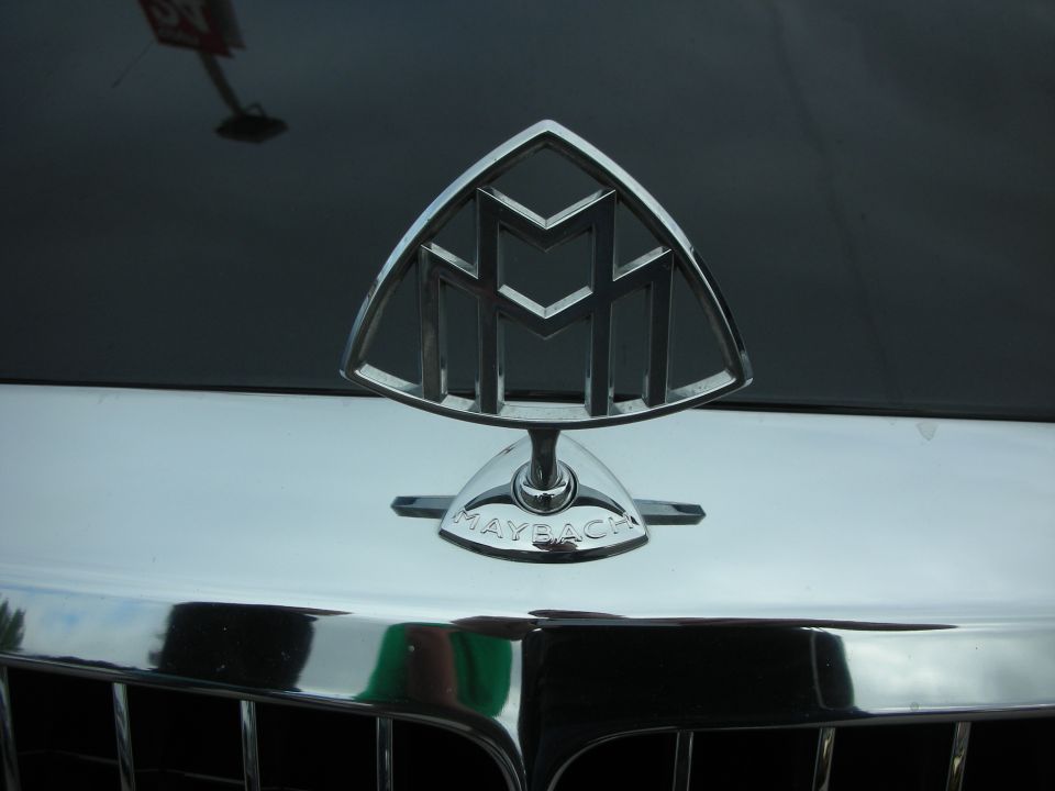 Close-up of chrome Maybach hood emblem on a dark car