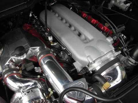 1998 Ford Crown Victoria - Close-up of a large engine showing a silver intake manifold, polished charge piping, and red ignition wires.