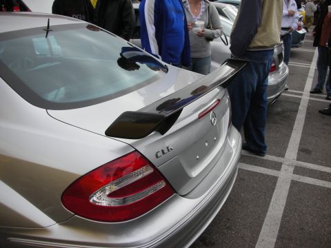 1998 Ford Crown Victoria - rear of a silver Mercedes-Benz CLK shows a black trunk spoiler, tail light, and CLK badge at a car show.