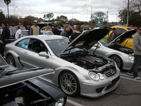 1998 Ford Crown Victoria - Silver Mercedes-Benz CLK coupes line up with hoods open as people browse the cars at an outdoor show.