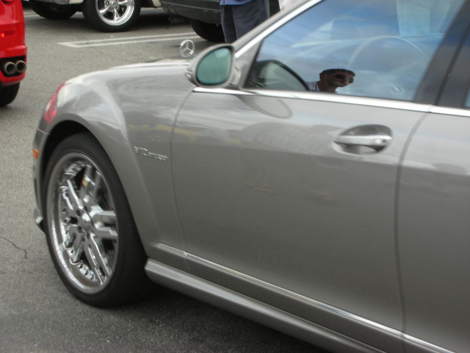 Side and front fender of a silver Mercedes-Benz sedan with chrome wheels