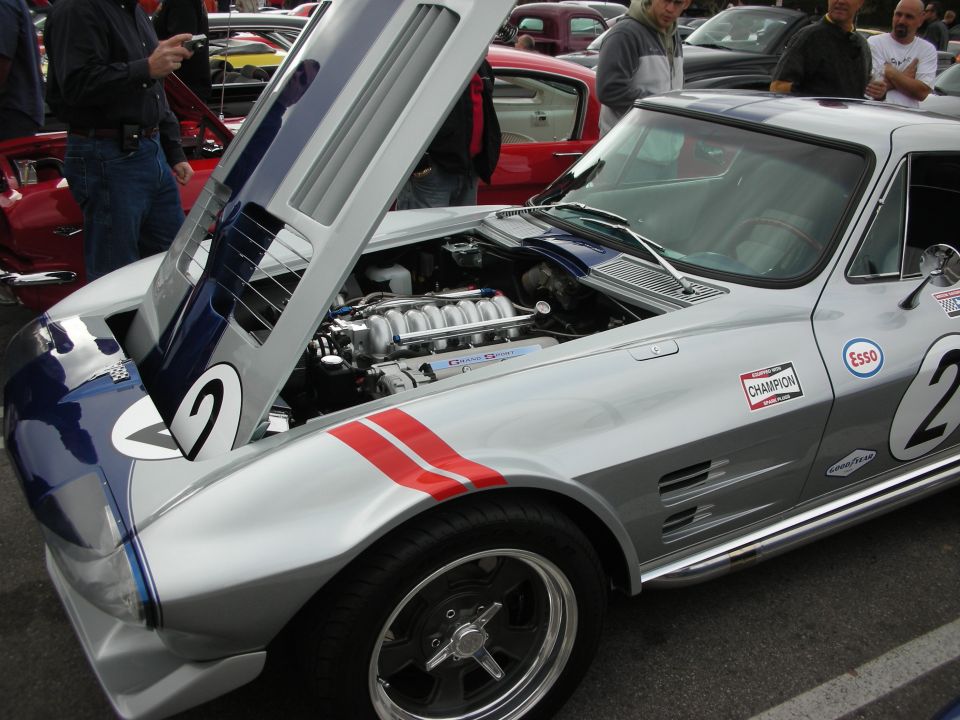 Front of silver number 2 Corvette race car with open hood and red stripe