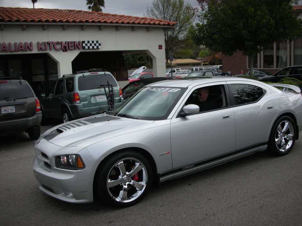 Silver Dodge Charger SRT8 sedan with chrome wheels parked outside a restaurant