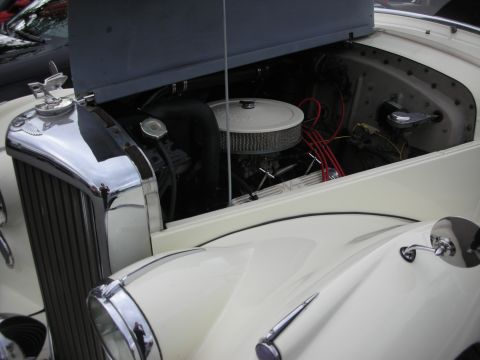 1998 Ford Crown Victoria - Engine bay of a cream-colored classic Bentley showing a chrome air cleaner, red plug wires, and chrome grille shell.