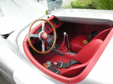 1998 Ford Crown Victoria - Interior of a silver Jaguar roadster with red leather seats, a wood-rimmed steering wheel, and a racing harness.