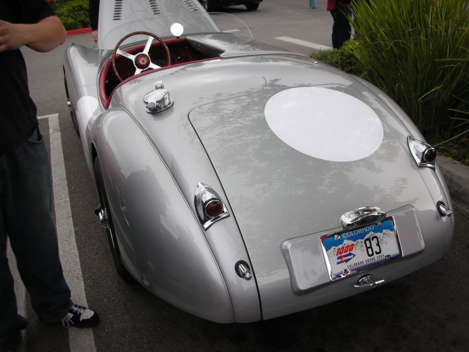 Rear of silver Jaguar roadster with white roundel and Colorado plate marked 83
