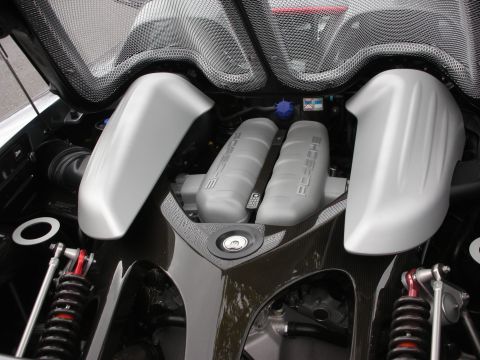 1998 Ford Crown Victoria - mid-mounted Porsche engine shown under carbon-look bodywork with silver intake covers and visible coilover suspension.