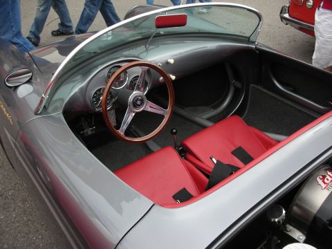 1998 Ford Crown Victoria - cockpit of a gray sports roadster featuring a wood-rimmed steering wheel, classic gauges and red leather seats.