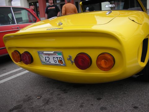 1998 Ford Crown Victoria - Rear view of a yellow Ferrari-style coupe with round taillights, a prancing-horse badge and a plate reading 62 GTR.