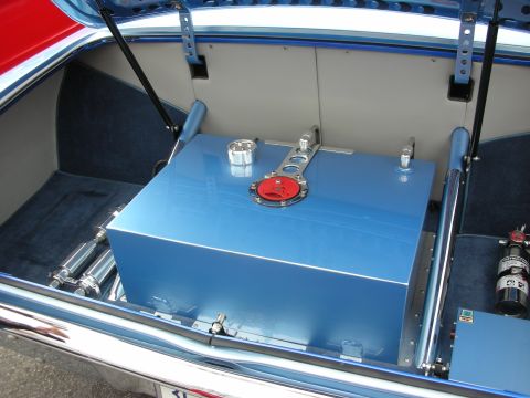 1998 Ford Crown Victoria - polished blue aluminum fuel cell with a red filler cap mounted in the blue-carpeted trunk of a custom car.