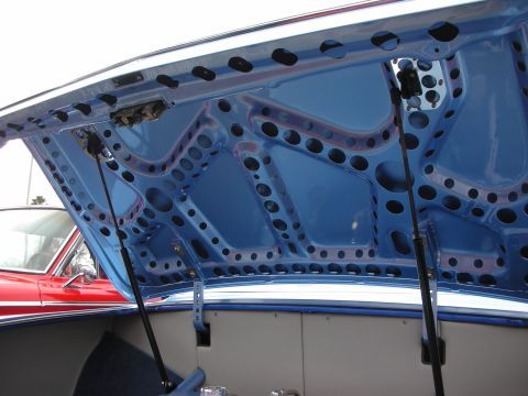 1998 Ford Crown Victoria - underside of a blue custom car's trunk lid showing extensive drilled lightening holes in a sculpted pattern.
