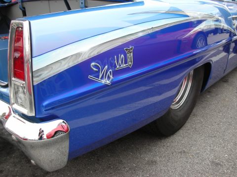 1998 Ford Crown Victoria - rear quarter panel of a blue custom Chevrolet showing chrome trim, a tail fin and a Nova SS script emblem.