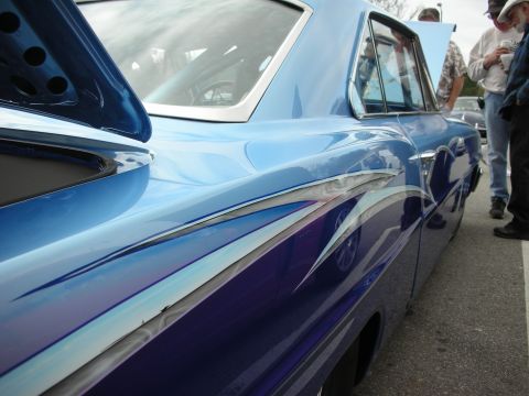 1998 Ford Crown Victoria - side of a blue custom car detailed with layered multicolor flame and scallop paint and chrome side trim.