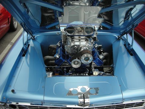 1998 Ford Crown Victoria - polished supercharged V8 with a chrome blower and twin scoops fills the light-blue engine bay of a show car.