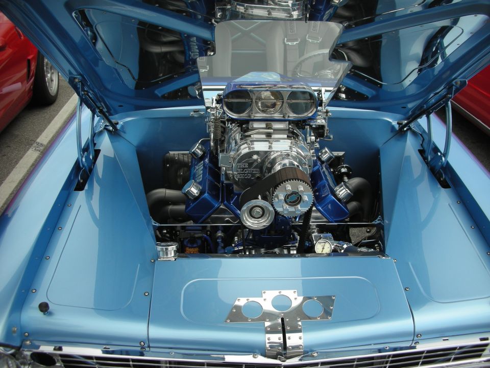 Chromed blower and supercharger atop a polished V8 in a light-blue engine bay