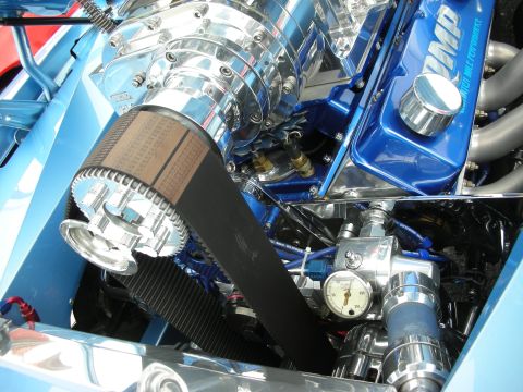 1998 Ford Crown Victoria - close-up of a chrome supercharger drive, wide belt, blue valve cover and pressure gauge in a detailed engine bay.