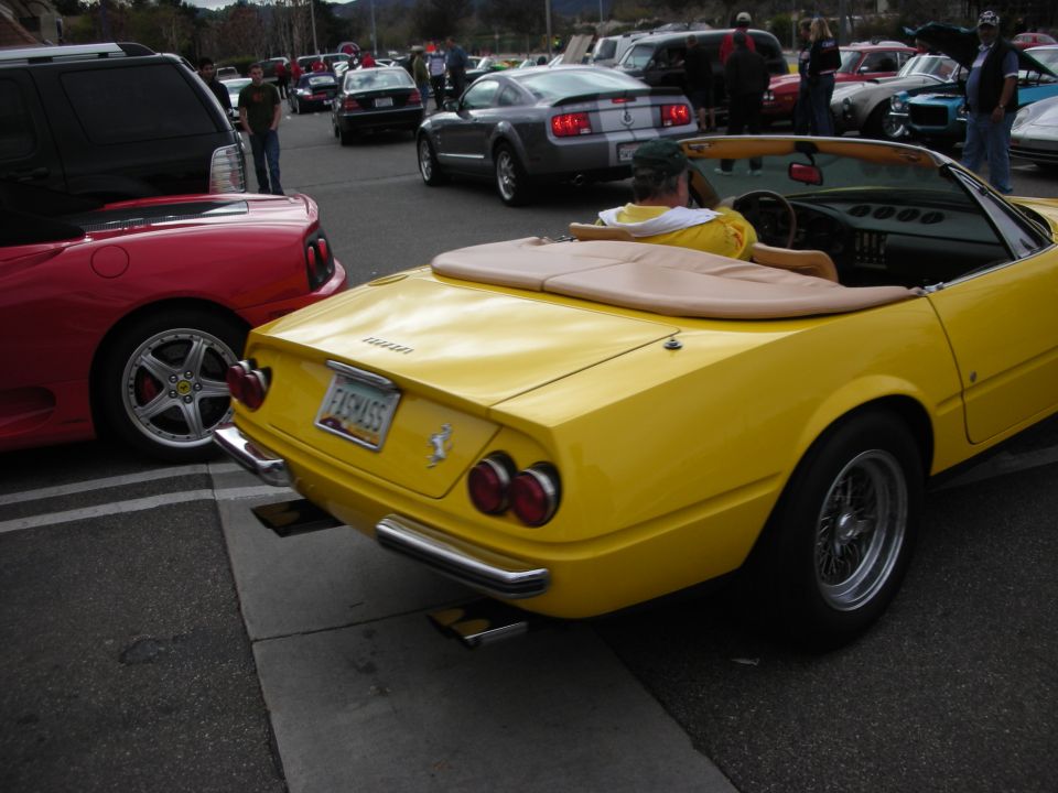 Yellow Ferrari Daytona Spyder among exotic cars in a crowded lot