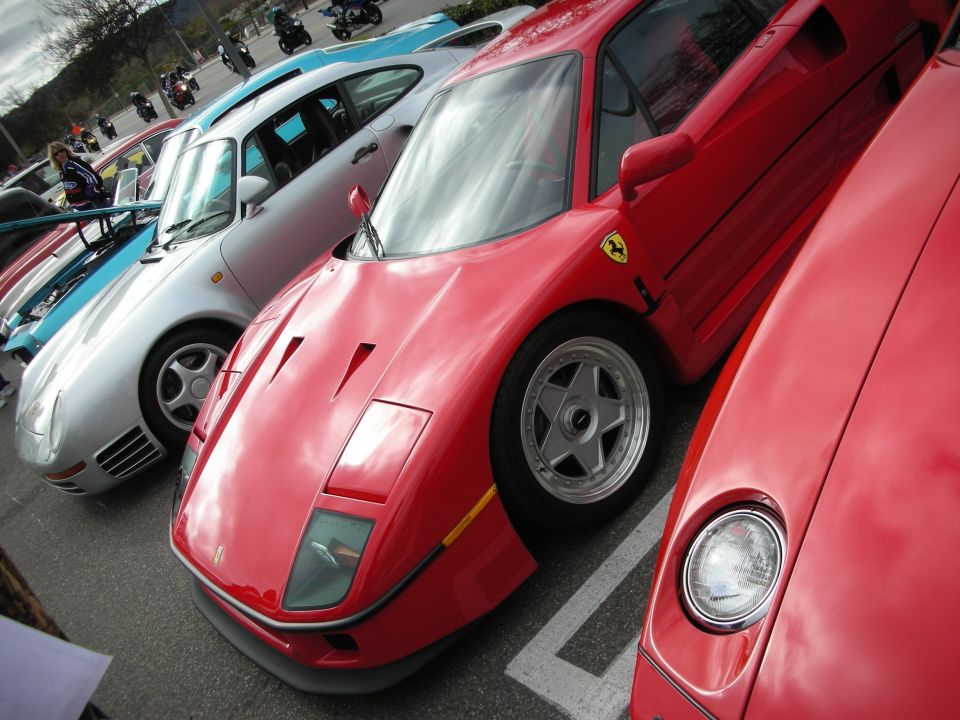 Red Ferrari F40 between a silver Porsche 959 and another red Ferrari