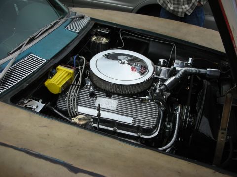1998 Ford Crown Victoria - engine bay of a Corvette showing a chrome-topped V8 with finned valve covers, a large round air cleaner and a yellow oil filter.