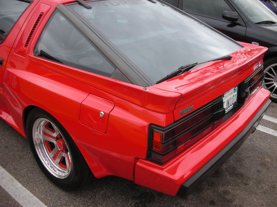 Red Mitsubishi Starion rear three-quarter showing TURBO graphics and rear spoiler