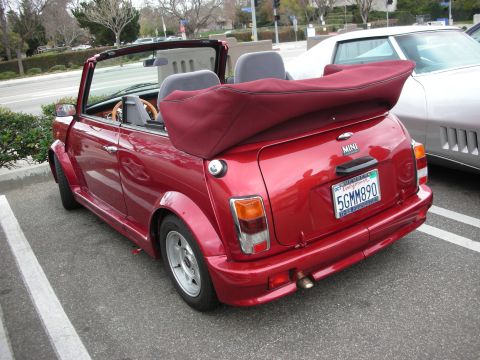 1998 Ford Crown Victoria - Rear three-quarter view of a red classic Mini convertible with top folded down, Mini badge and California plate reading 5GMM890.
