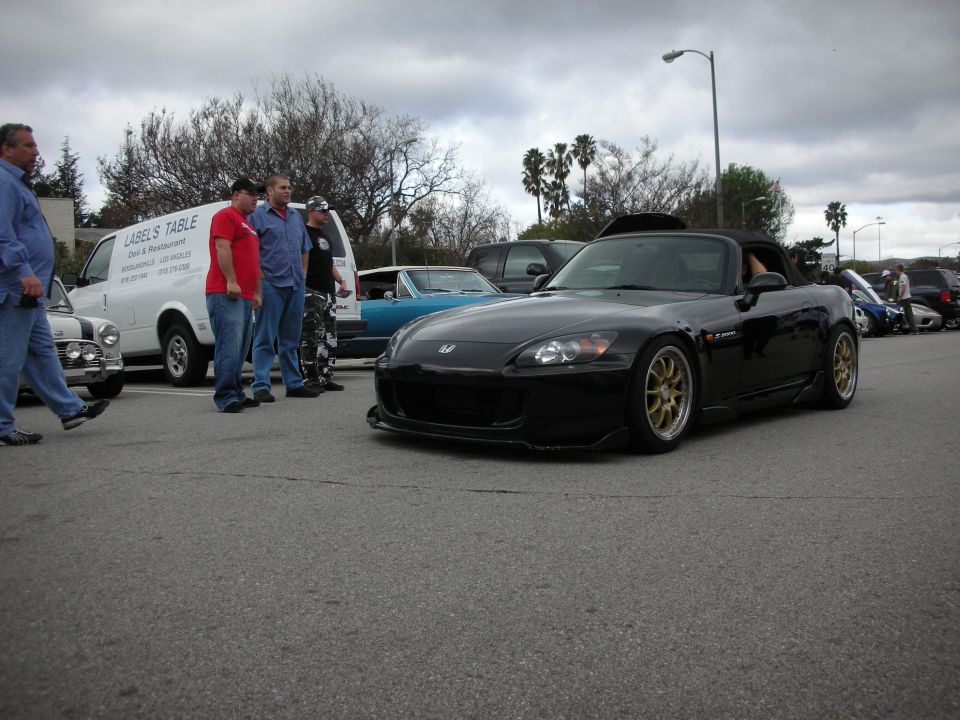 Black Honda S2000 convertible with gold wheels at a car meet