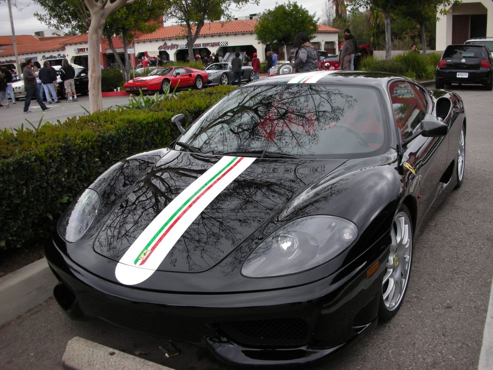 Black Ferrari 360 with Italian tricolor stripe at a car show