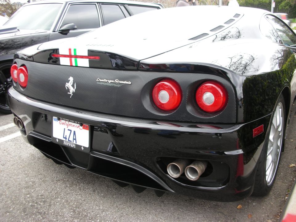 Rear of black Ferrari 360 Challenge Stradale with round taillights, twin exhausts and California plate