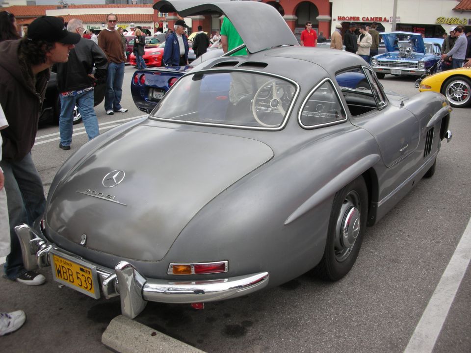 Rear three-quarter of gray Mercedes 300SL Gullwing coupe with raised door at a car show